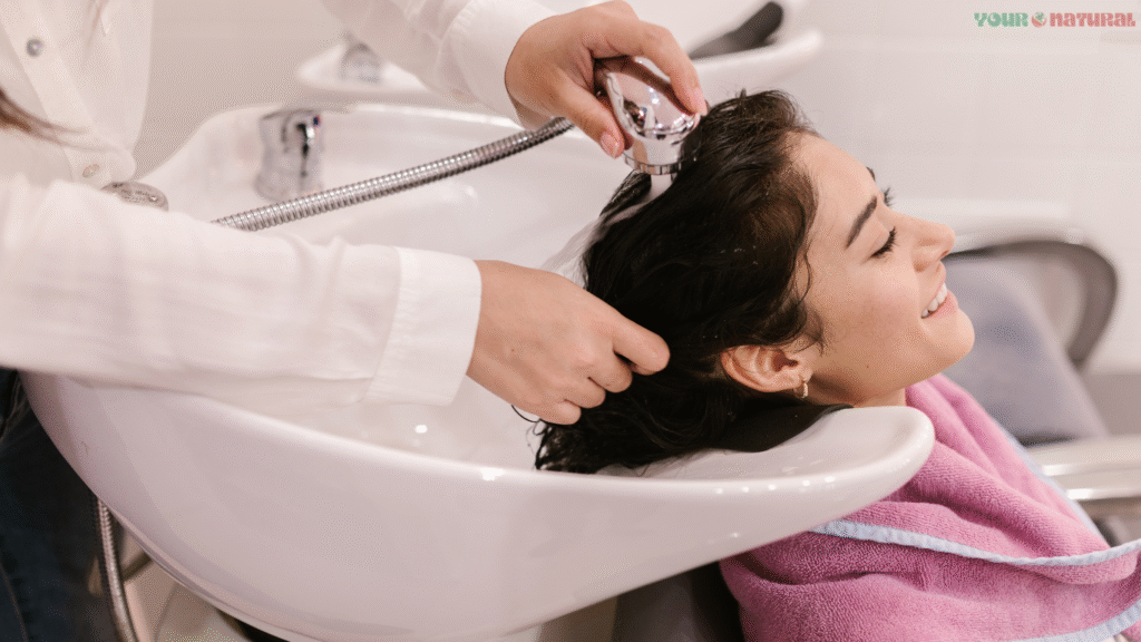 Woman enjoying a relaxing hair wash at a salon as part of her hair care routine.