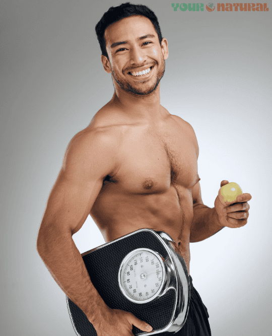 How to boost testosterone naturally – fit man holding a weight scale and an apple